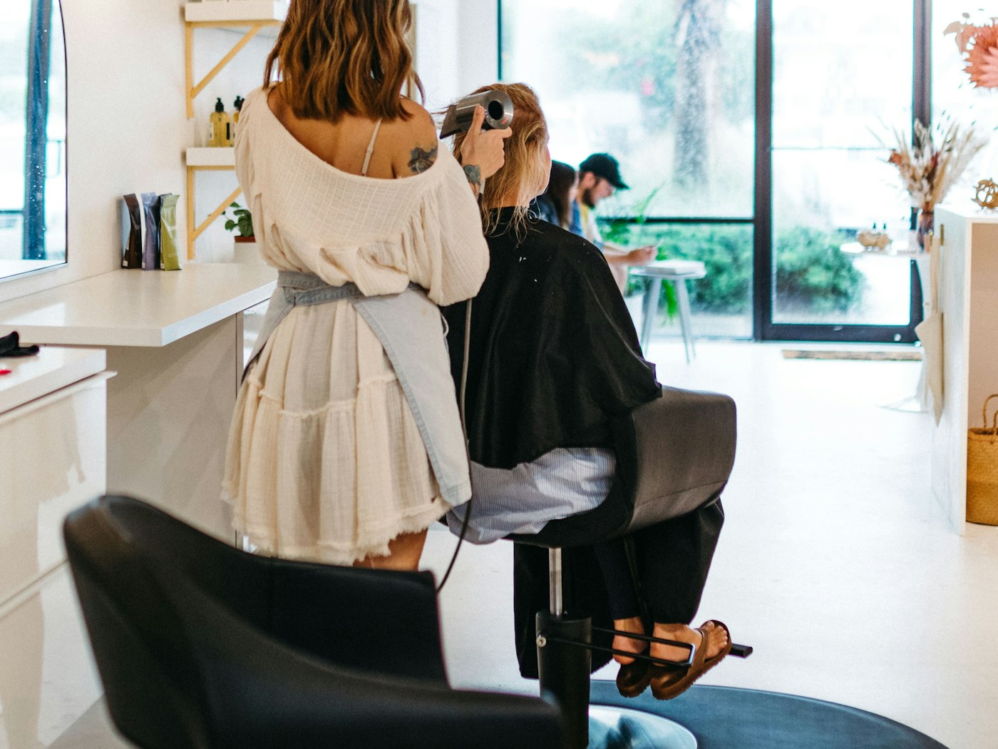 The studio floor: a client mid blow-dry by the window