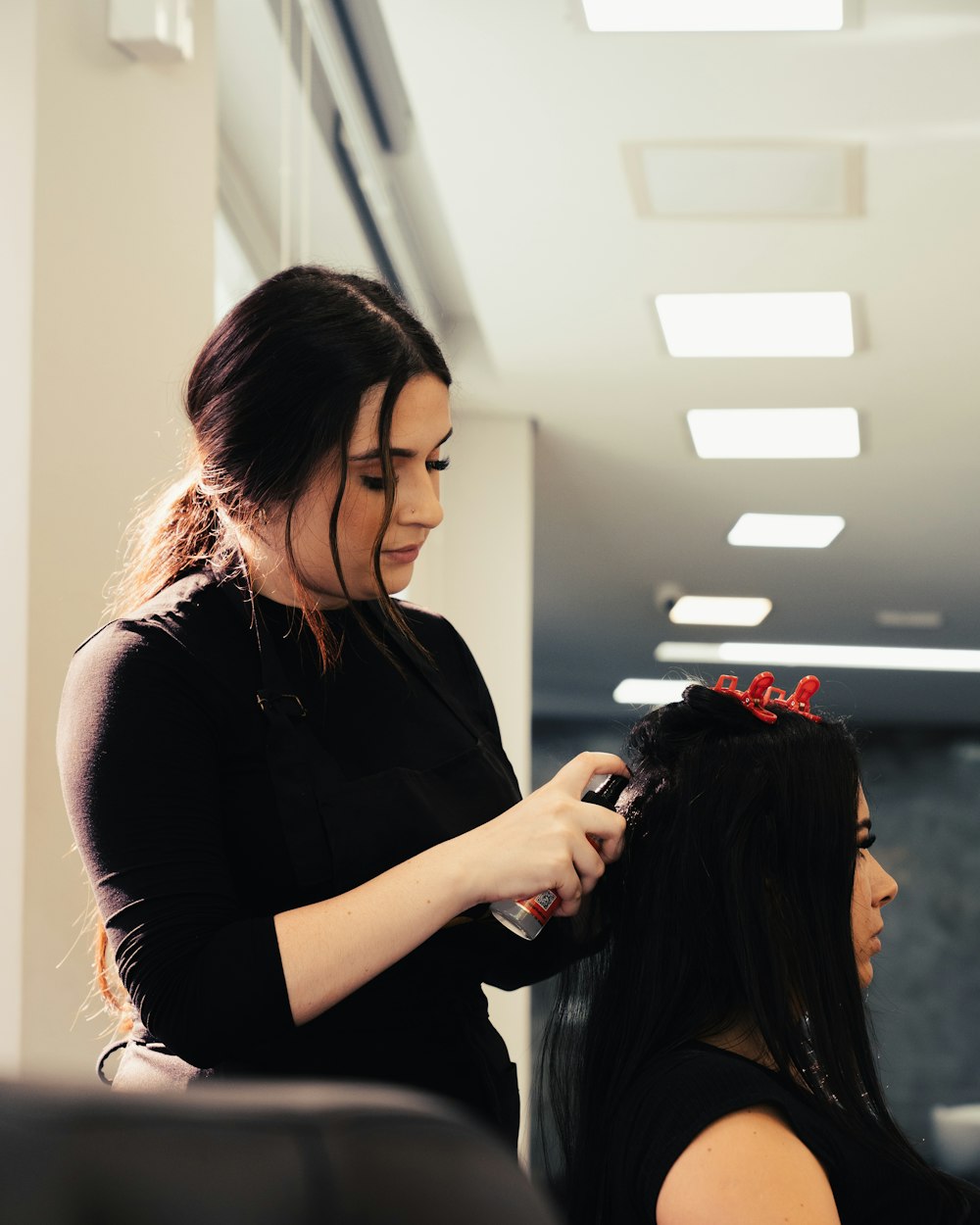 Robyn finishing a client's hair at the mirror